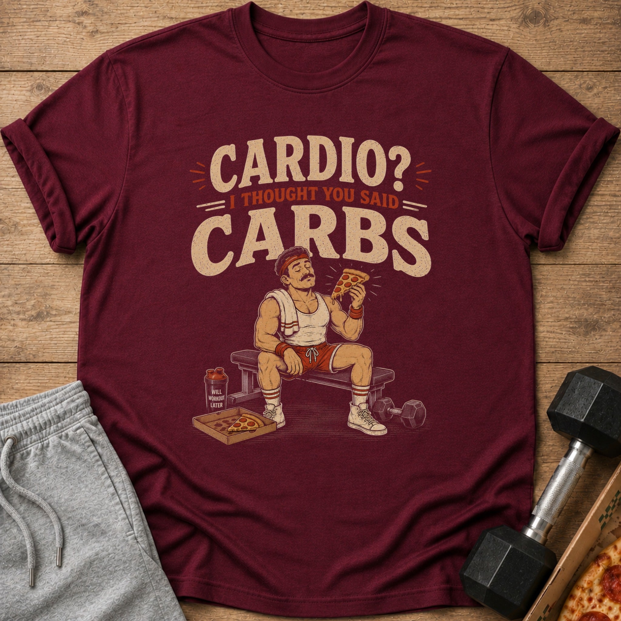 Maroon t-shirt with "Cardio? I thought you said Carbs" text and cartoon man eating pizza.