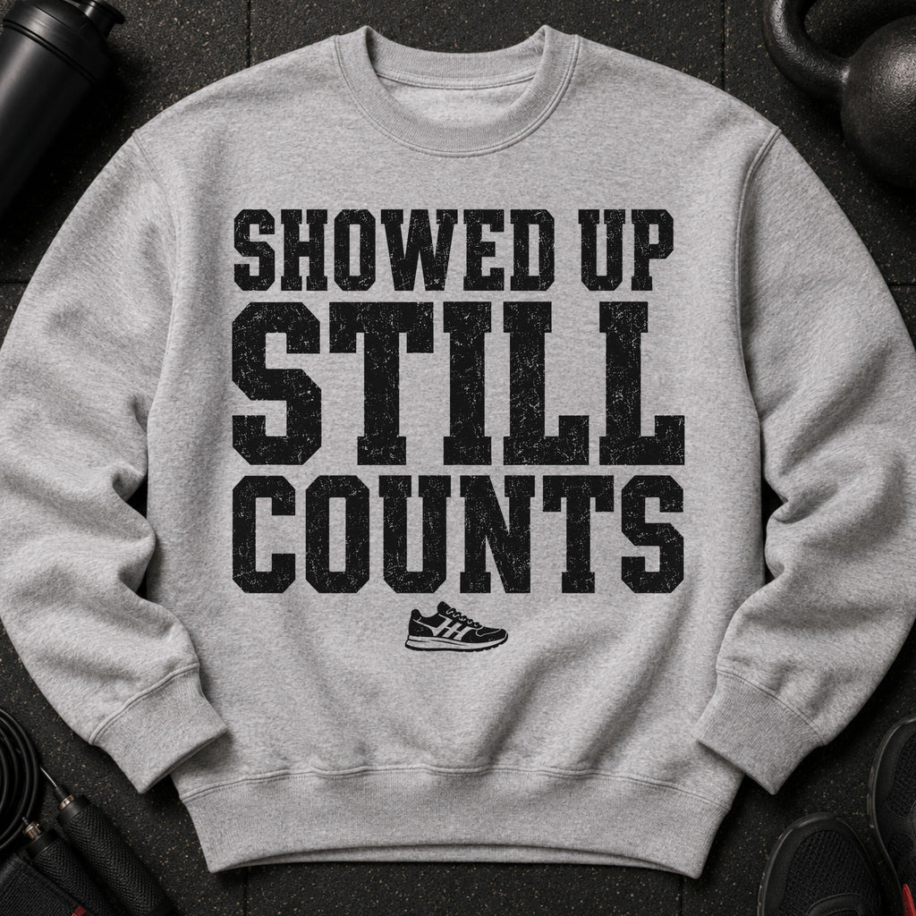 Grey sweatshirt with black distressed text "SHOWED UP STILL COUNTS" and a shoe graphic.