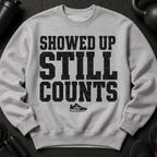 Grey sweatshirt with black distressed text "SHOWED UP STILL COUNTS" and a shoe graphic.
