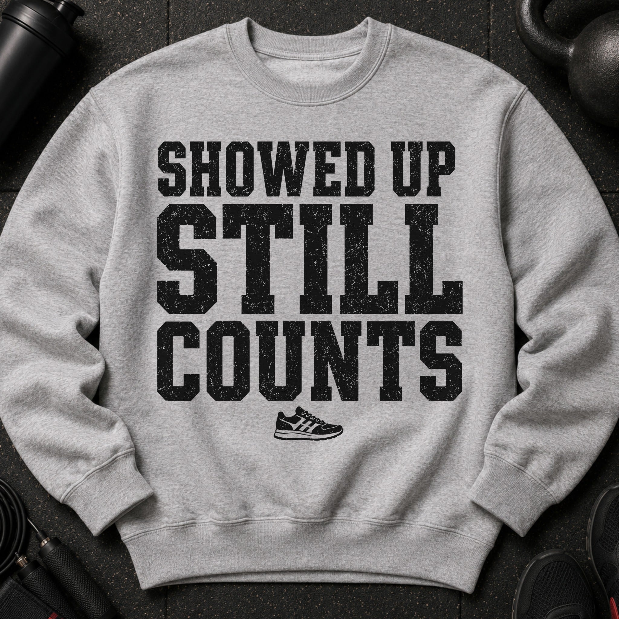 Grey sweatshirt with black distressed text "SHOWED UP STILL COUNTS" and a shoe graphic.