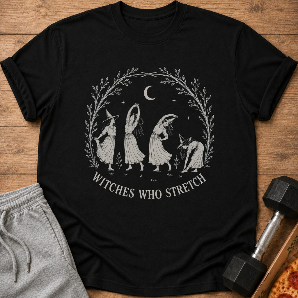 Black t-shirt with a circular design of witches stretching under a crescent moon and stars.