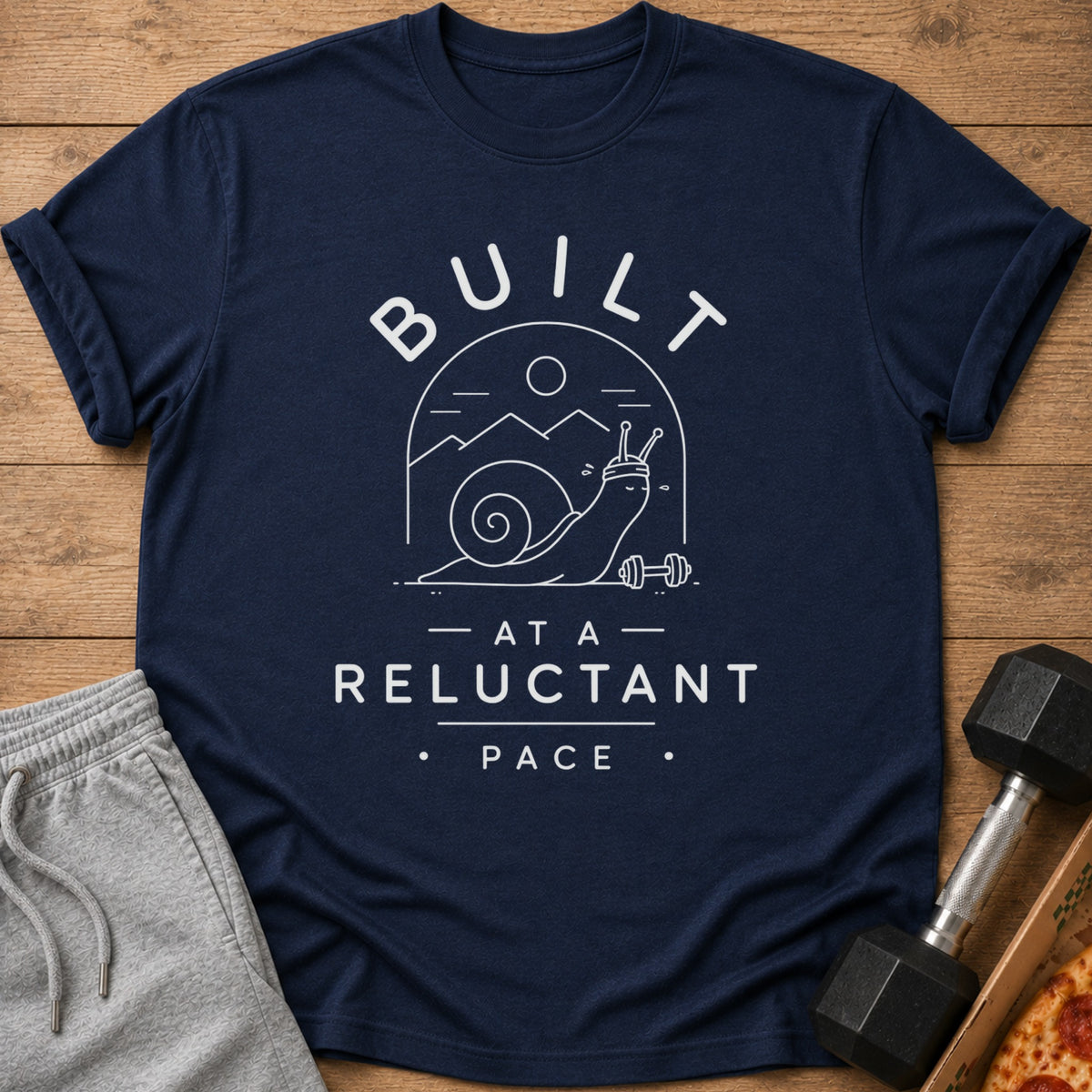 Navy t-shirt with white graphic of a snail lifting weights and text "BUILT AT A RELUCTANT PACE".