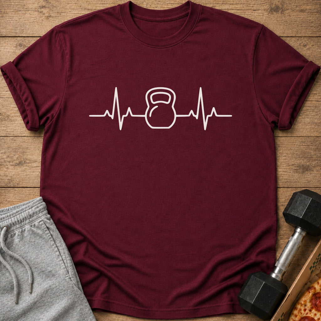 Maroon t-shirt with white kettlebell heartbeat graphic, next to grey sweatpants and a dumbbell.
