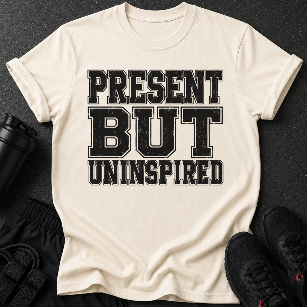 Cream t-shirt with black text reading "PRESENT BUT UNINSPIRED".