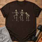 Brown t-shirt with three dancing skeletons and fallen leaves graphic.