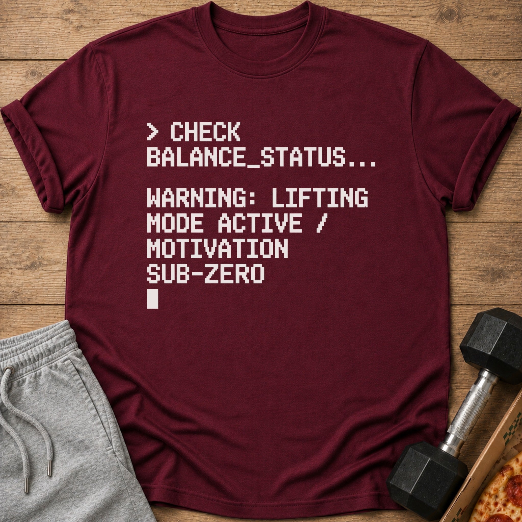 Maroon t-shirt with white pixelated text about checking balance and lifting mode.