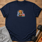 Navy t-shirt with a cartoon capybara wrapped in a blanket holding a dumbbell and a donut.