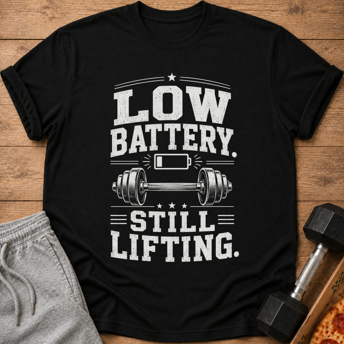 Black t-shirt with "Low Battery. Still Lifting." text and dumbbell graphic.