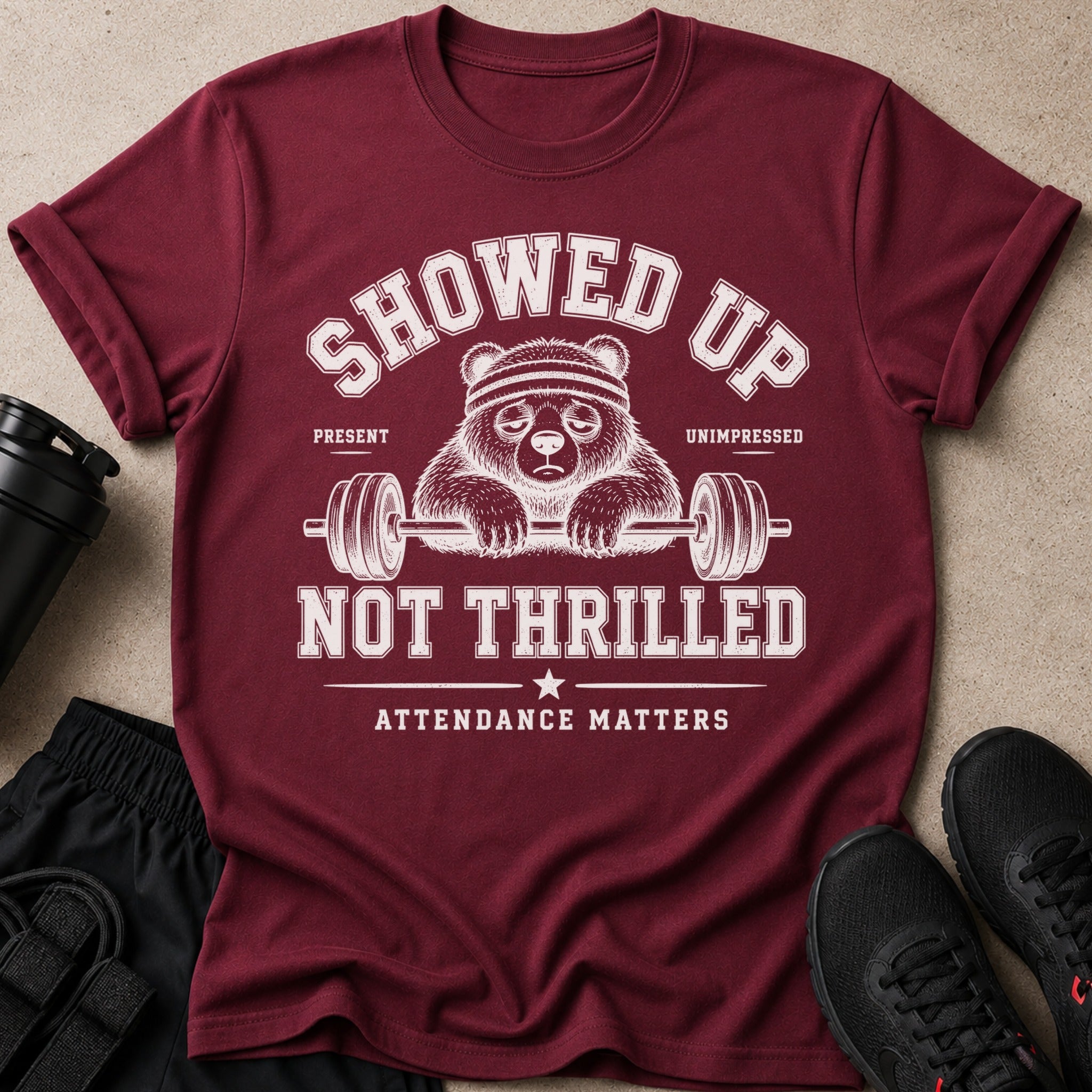 Maroon t-shirt with a panda lifting weights and text that reads "Showed Up Unimpressed Not Thrilled Attendance Matters".