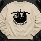 Tan sweatshirt with black graphic of a sloth hanging from a bar, text reads "Snooze Button Athlete".