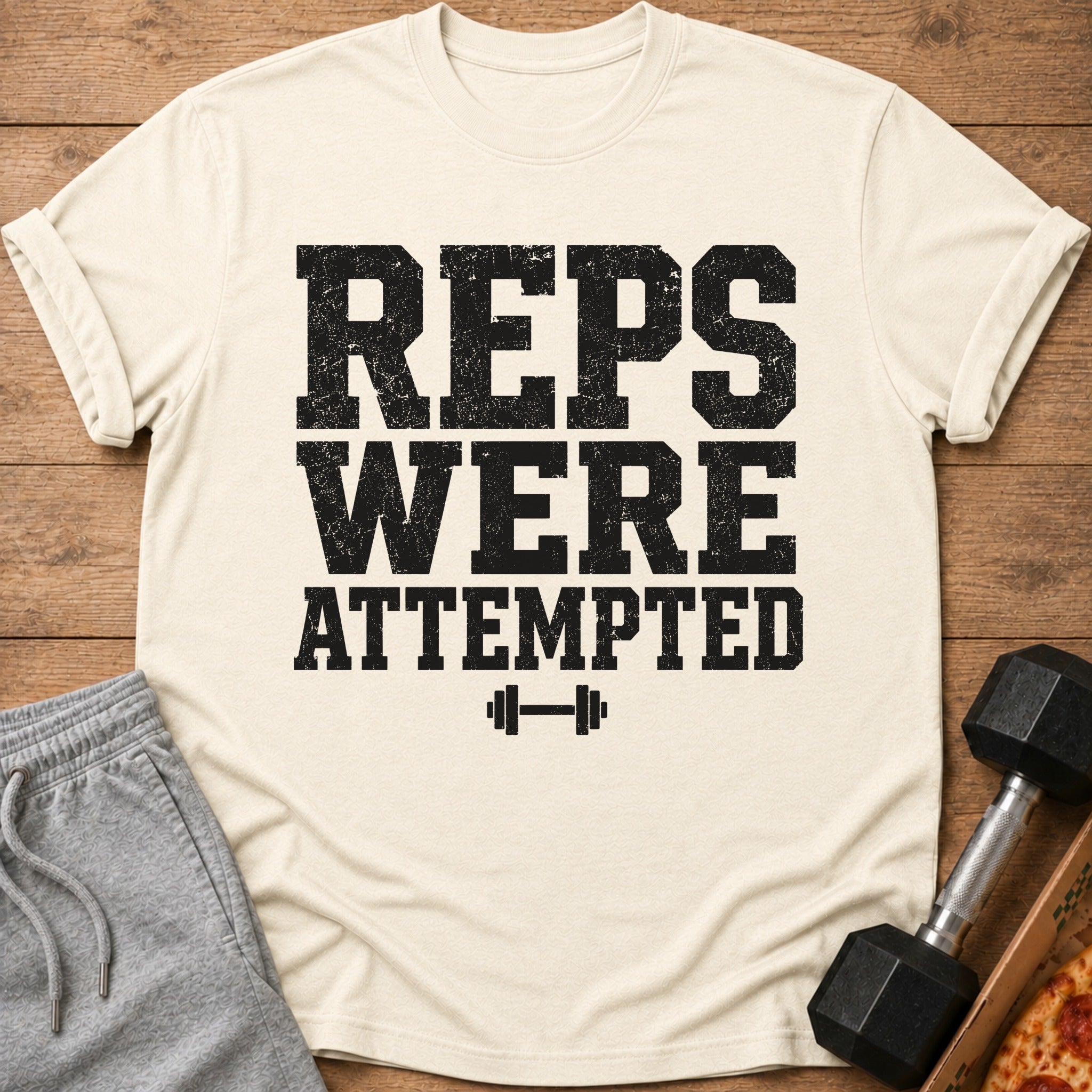 Cream t-shirt with "REPS WERE ATTEMPTED" text and barbell graphic.