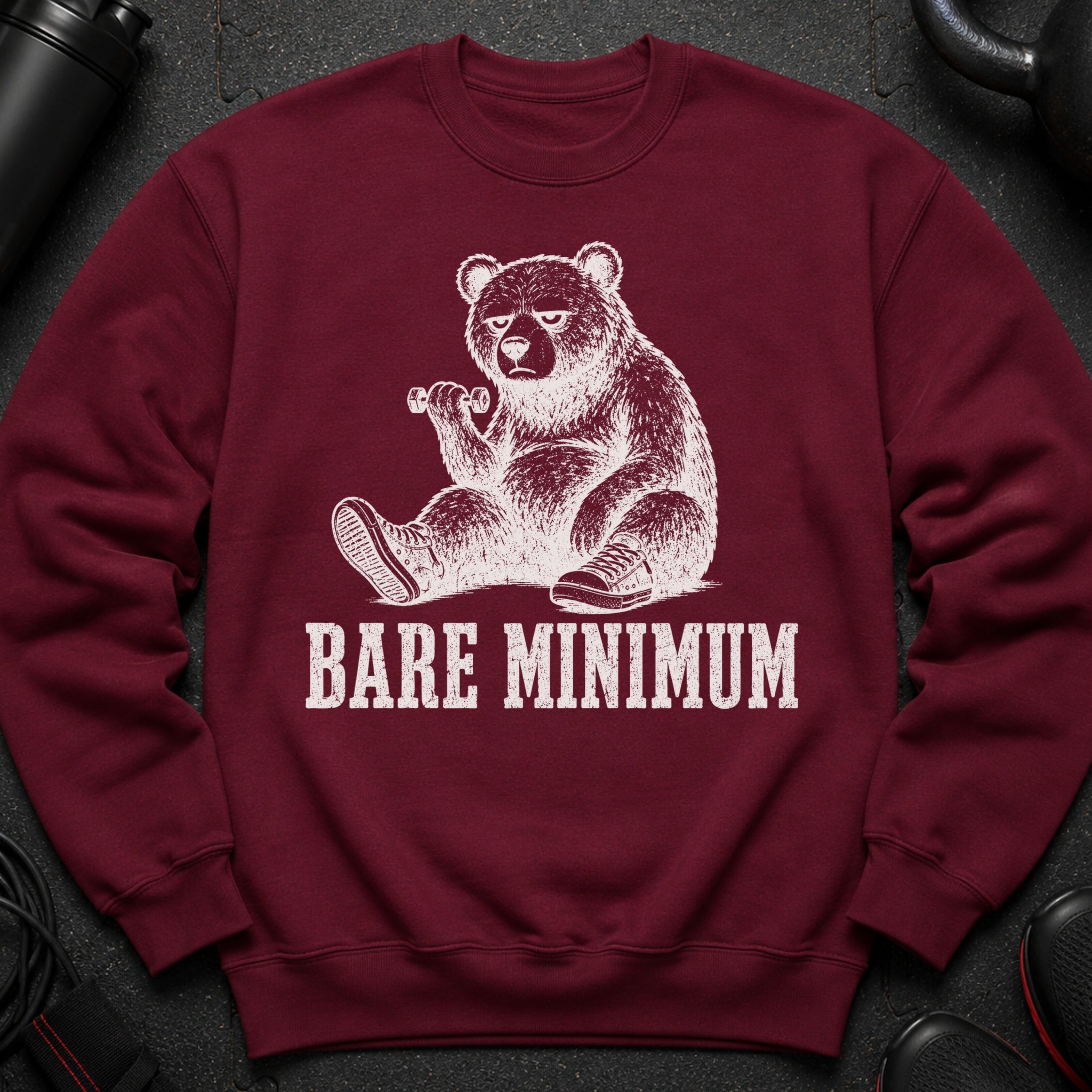 Maroon sweatshirt with a white graphic of a bear holding a dumbbell and the text "BARE MINIMUM".