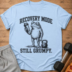 Light blue t-shirt with a grumpy frog holding a shaker bottle and text "RECOVERY MODE STILL GRUMPY."