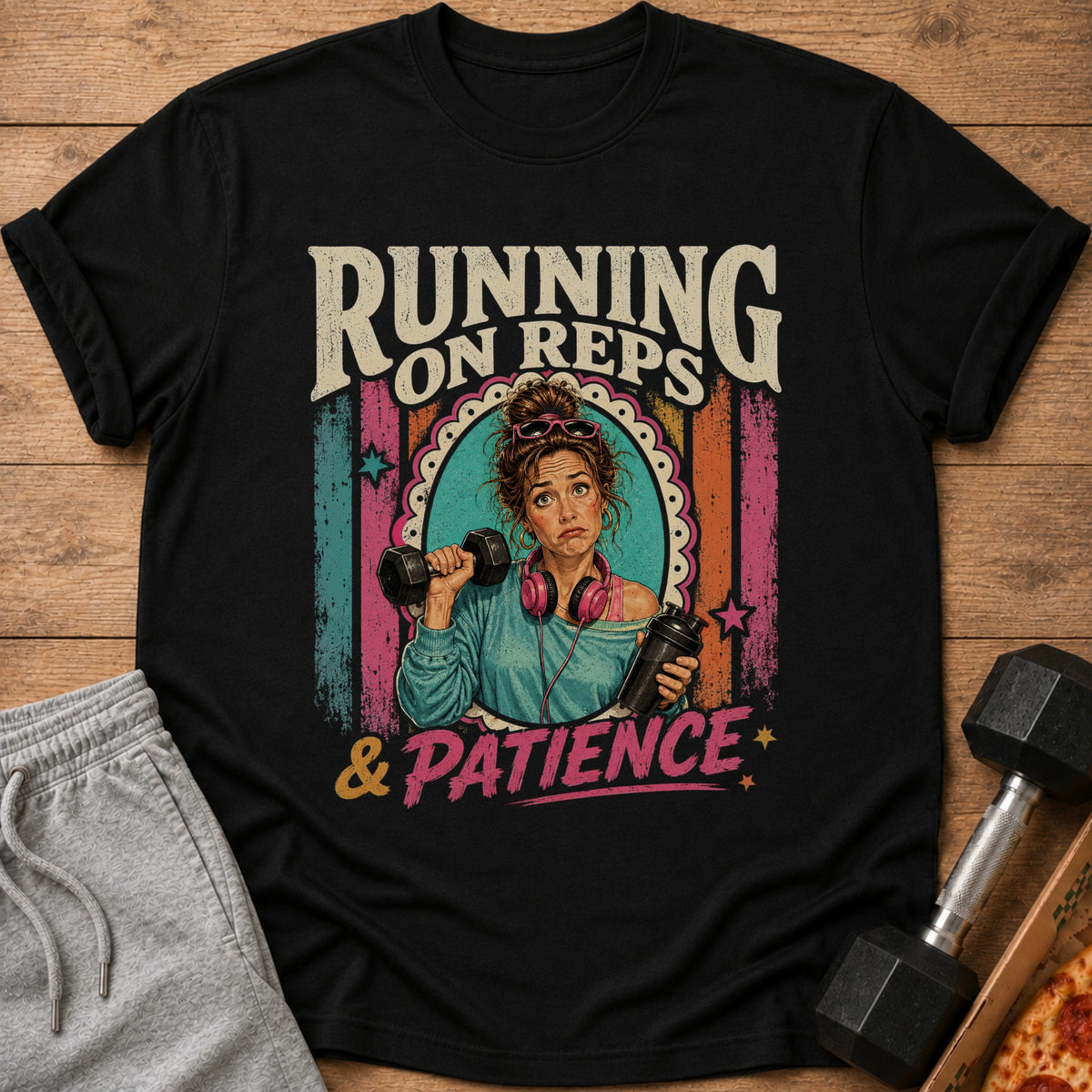 Black t-shirt with "Running on Reps & Patience" graphic featuring a woman with dumbbells and headphones.