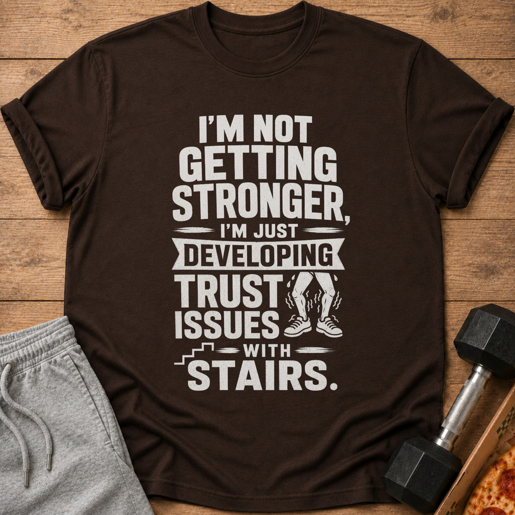 Brown t-shirt with "I'm Not Getting Stronger, I'm Just Developing Trust Issues With Stairs."