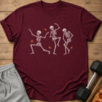 Maroon t-shirt with three dancing skeletons and autumn leaves graphic.