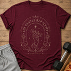 Maroon t-shirt with gold art depicting a hand holding a dumbbell and text.
