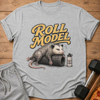 Opossum on foam roller with "Roll Model" text and "Hydrate or Die-Drated" water bottle.