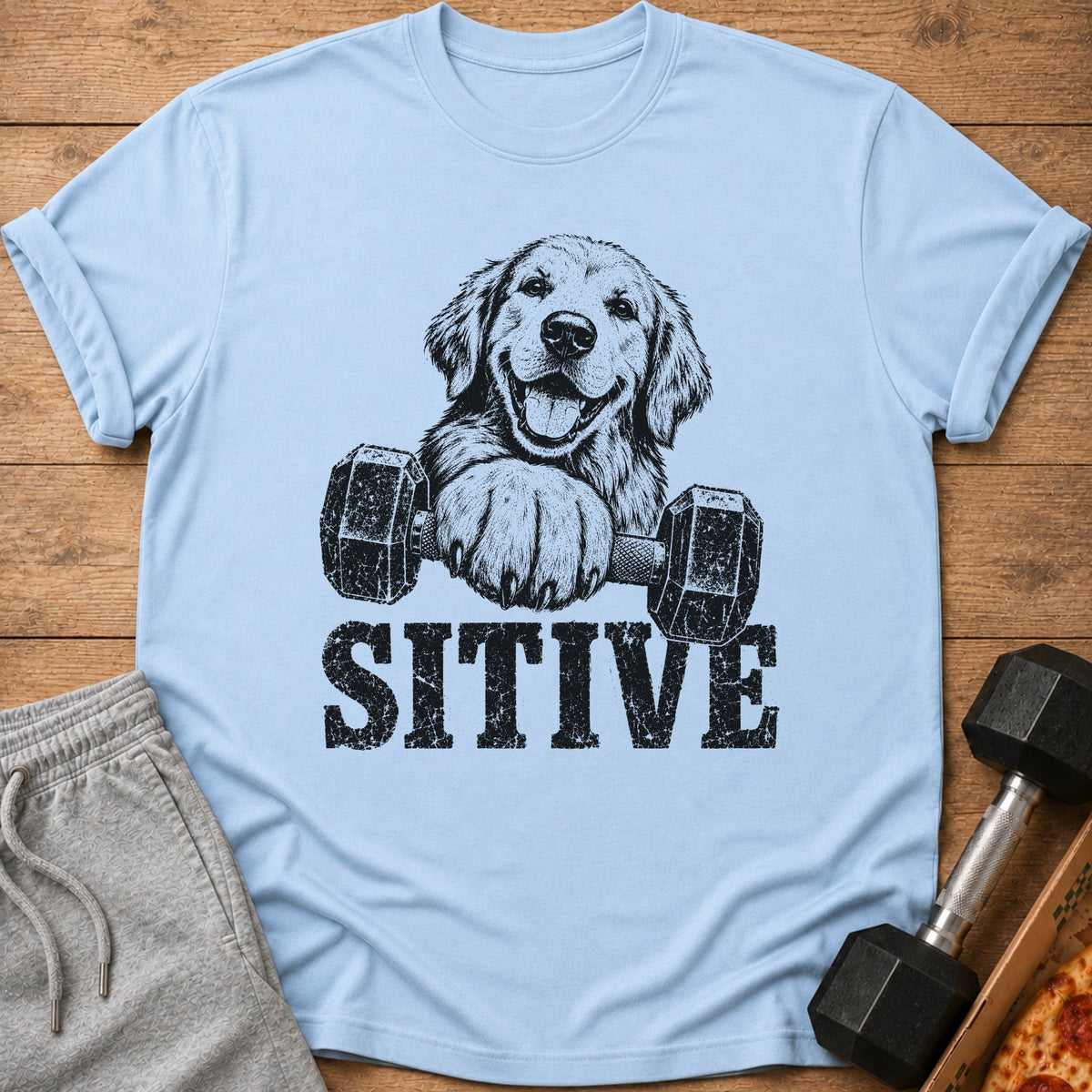 Light blue t-shirt with black graphic of dog holding dumbbell and "SITIVE" text.