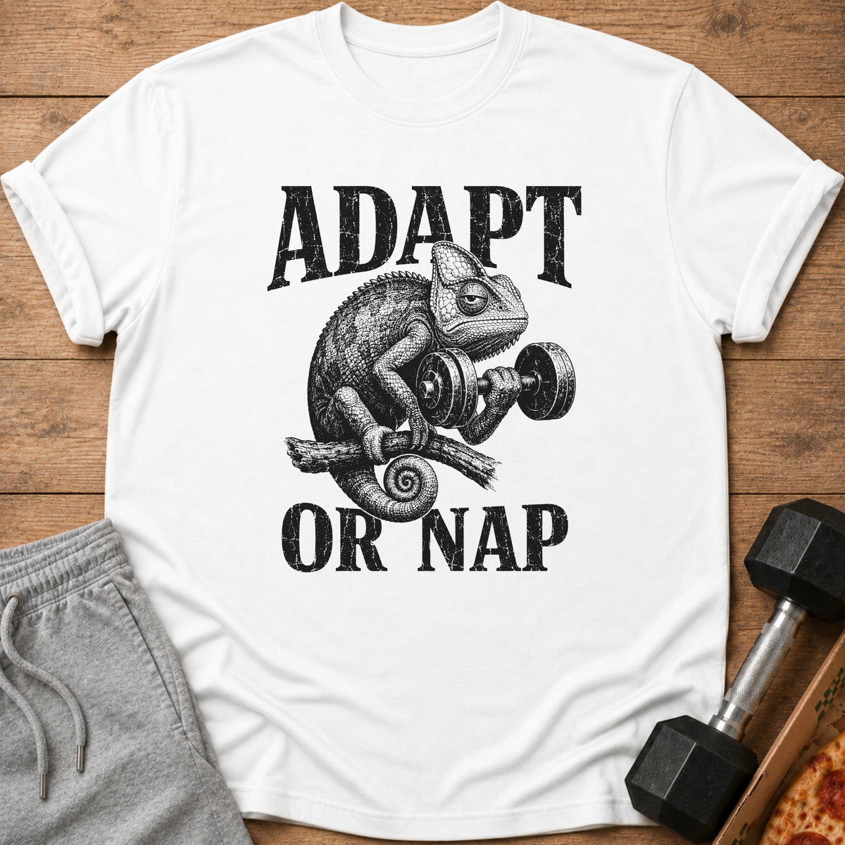 White t-shirt with graphic of chameleon lifting dumbbell and text "ADAPT OR NAP".