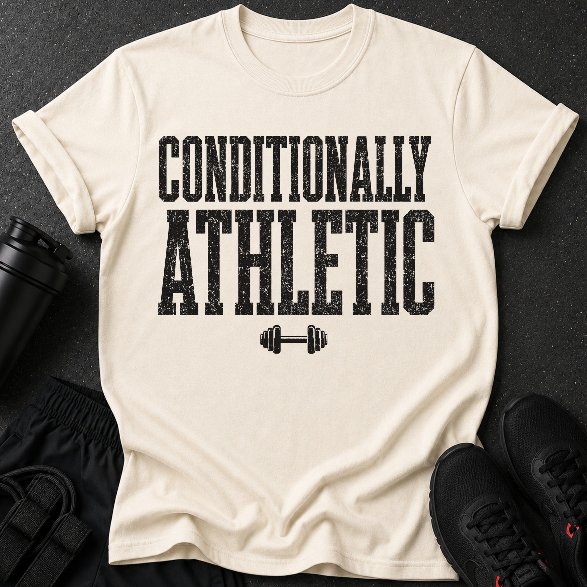 Cream t-shirt with black distressed text "CONDITIONALLY ATHLETIC" and a dumbbell graphic.