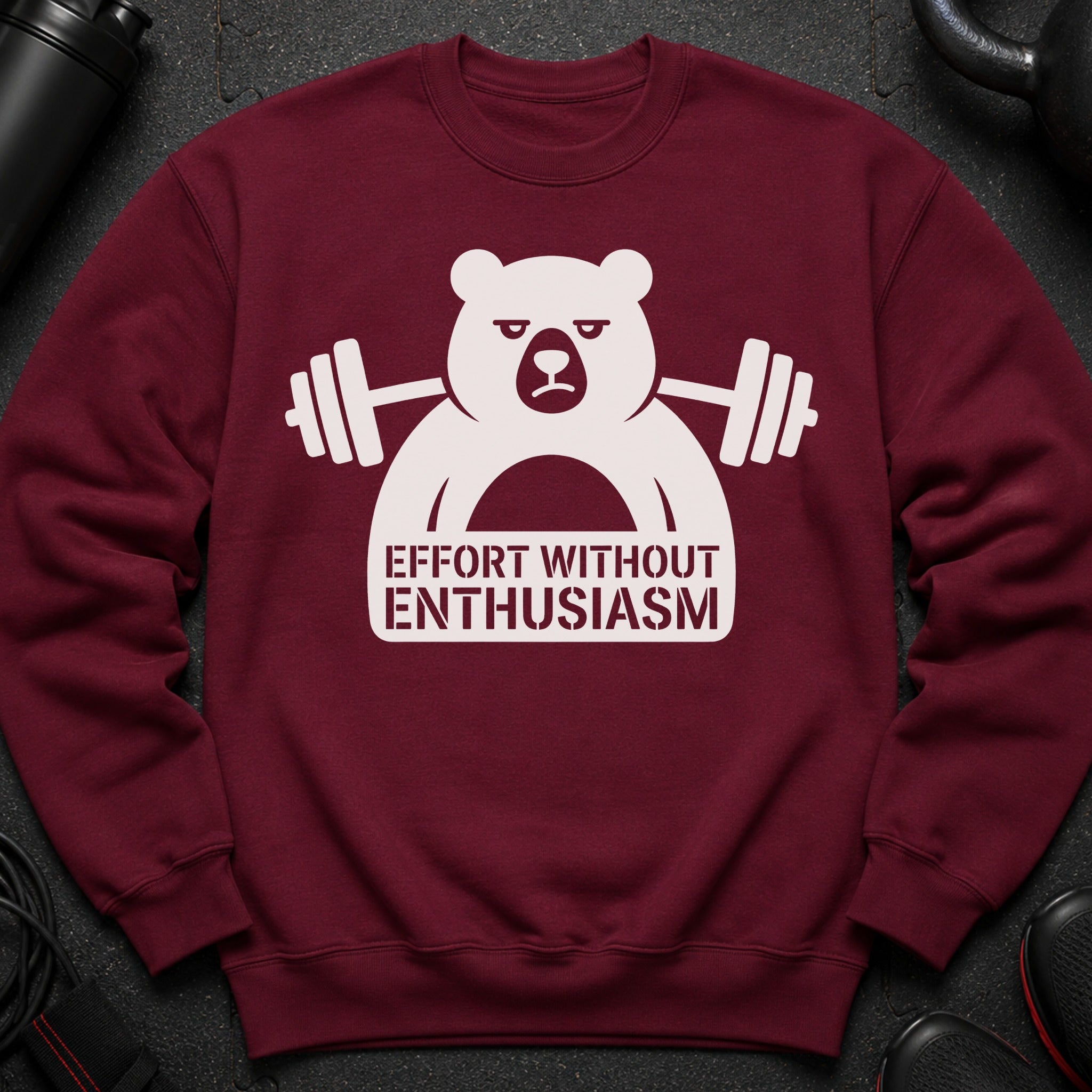 Burgundy sweatshirt with a white graphic of a bear lifting weights and text "Effort Without Enthusiasm".
