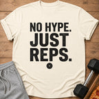 Cream t-shirt with black text "NO HYPE. JUST REPS." and a weight plate graphic.