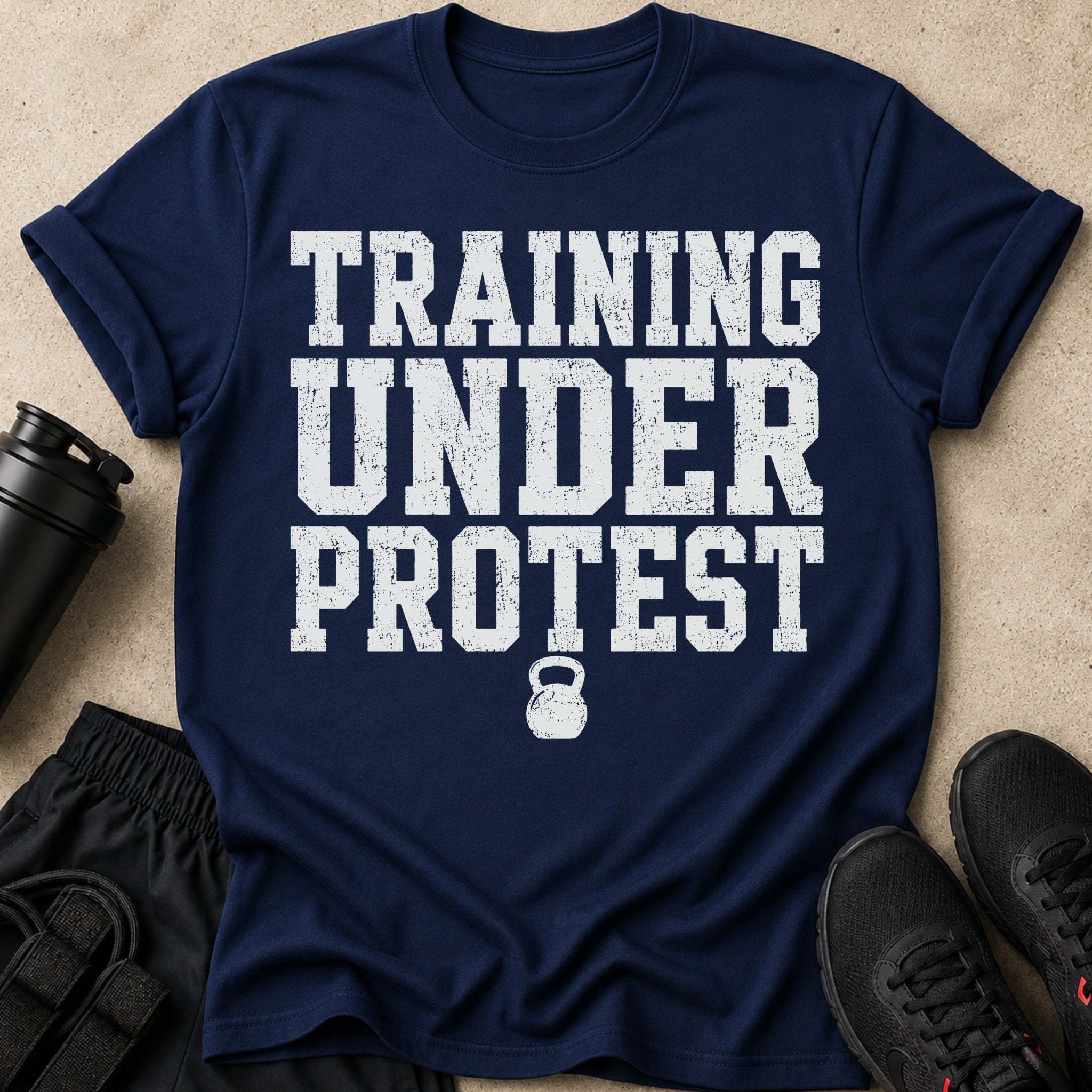 Navy t-shirt with white distressed text "TRAINING UNDER PROTEST" and a kettlebell graphic.