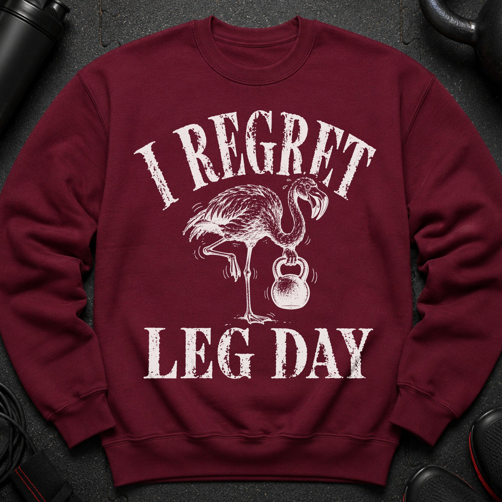 Maroon sweatshirt with distressed graphic of a flamingo lifting a kettlebell and text "I REGRET LEG DAY".