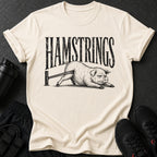 Cream t-shirt with black distressed print "HAMSTRINGS" above a pig with bands around its legs.