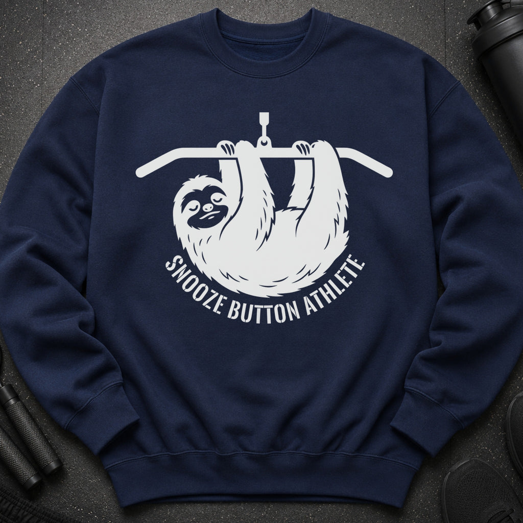 Navy sweatshirt with white graphic of a sloth hanging from a bar, reading "Snooze Button Athlete".