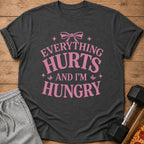 Dark grey t-shirt with pink text "EVERYTHING HURTS AND I'M HUNGRY".