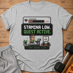 Pixel art shirt with "Stamina Low. Quest Active." and "Tiny Gains Club" text.