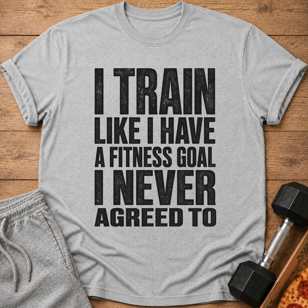 Gray t-shirt with black text "I TRAIN LIKE I HAVE A FITNESS GOAL I NEVER AGREED TO".