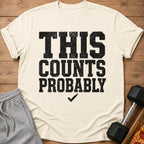 Cream t-shirt with black text "THIS COUNTS PROBABLY" and a checkmark.