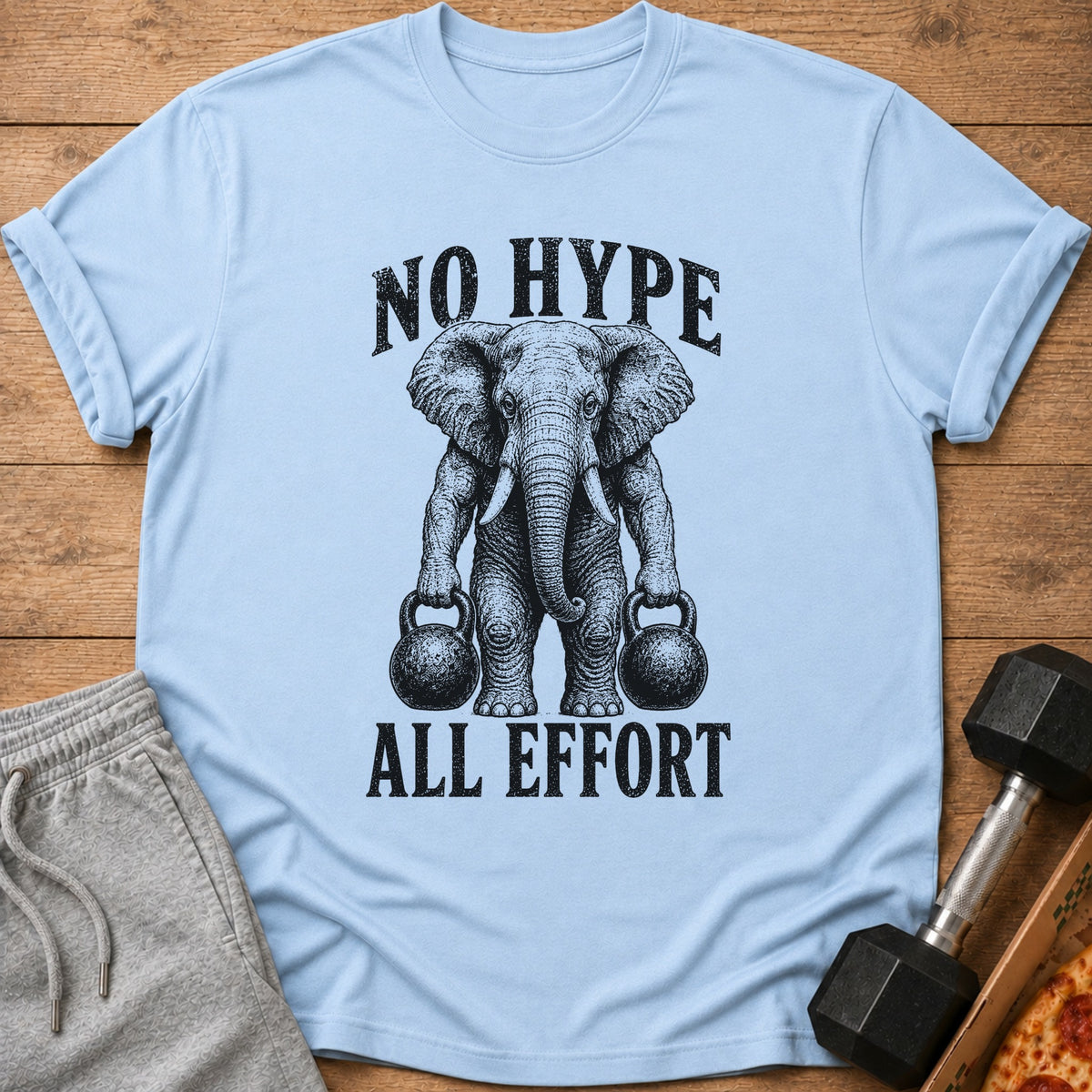 Light blue t-shirt with black graphic of elephant lifting kettlebells and text "NO HYPE ALL EFFORT".