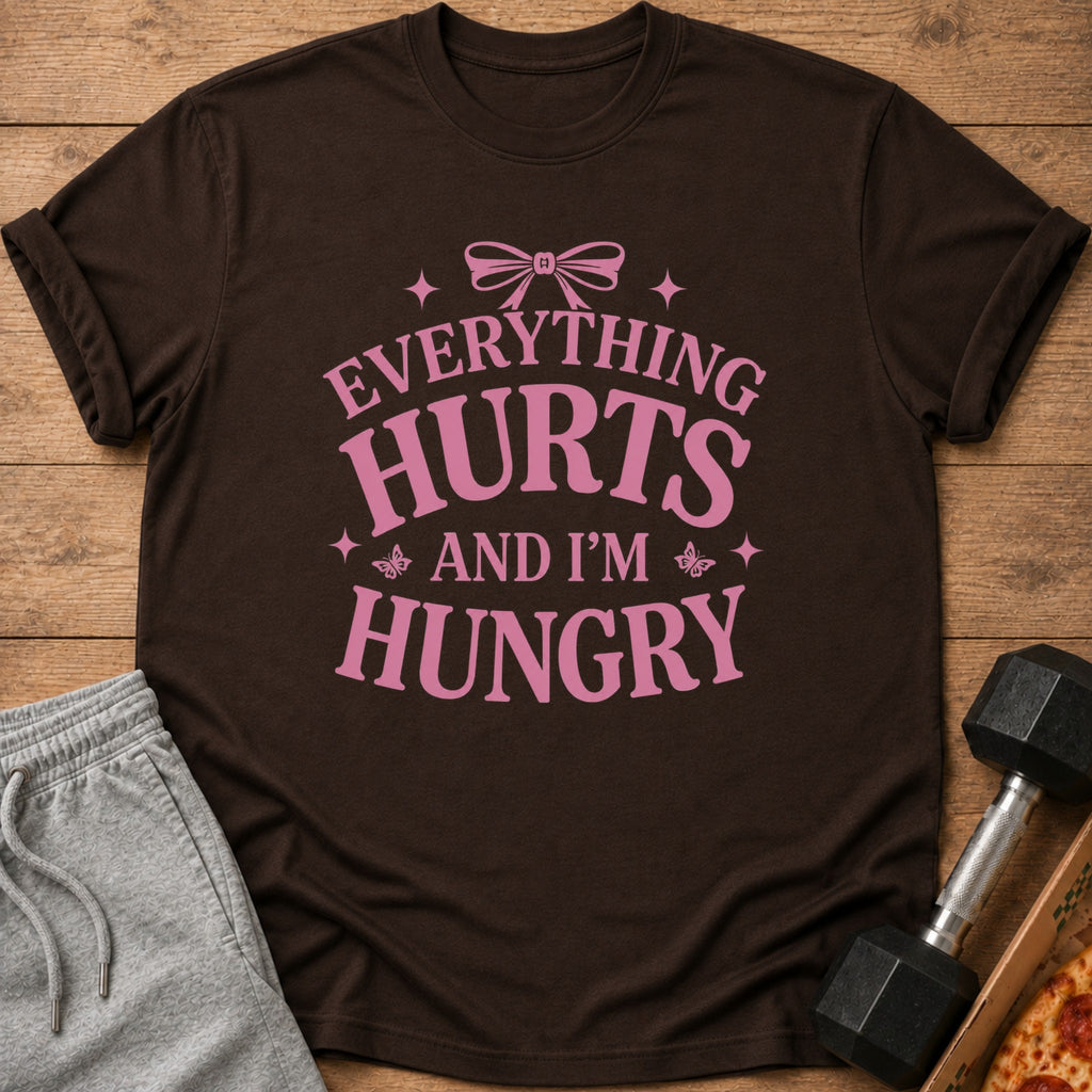 Brown t-shirt with pink text that says "Everything Hurts And I'm Hungry".