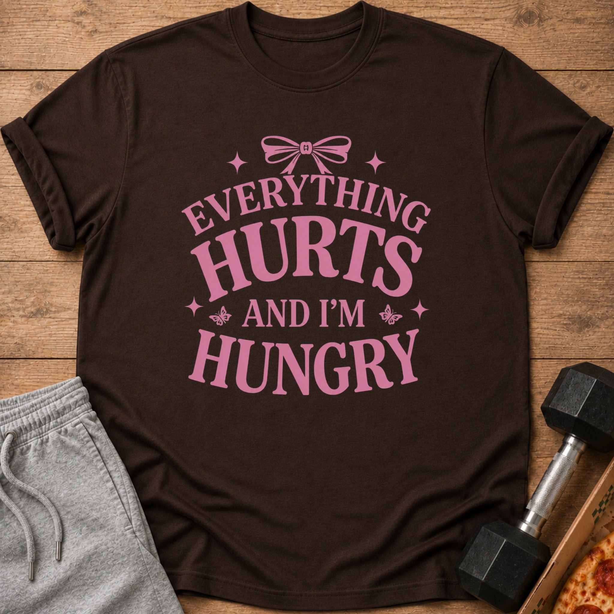 Brown t-shirt with pink text that says "Everything Hurts And I'm Hungry".