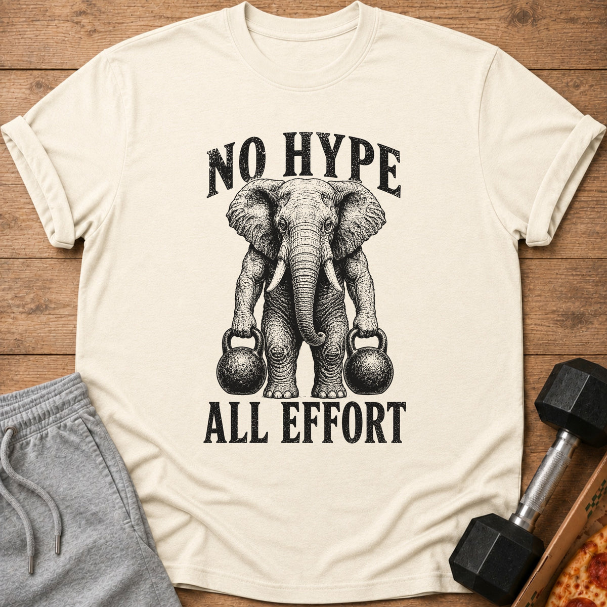 Cream t-shirt with an elephant holding kettlebells and text "NO HYPE ALL EFFORT".