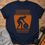 Dark blue t-shirt with distressed orange ancient Greek-style graphic of a man lifting a weight.