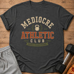 Charcoal t-shirt with "Mediocre Athletic Club" text, kettlebell, and ribbon.