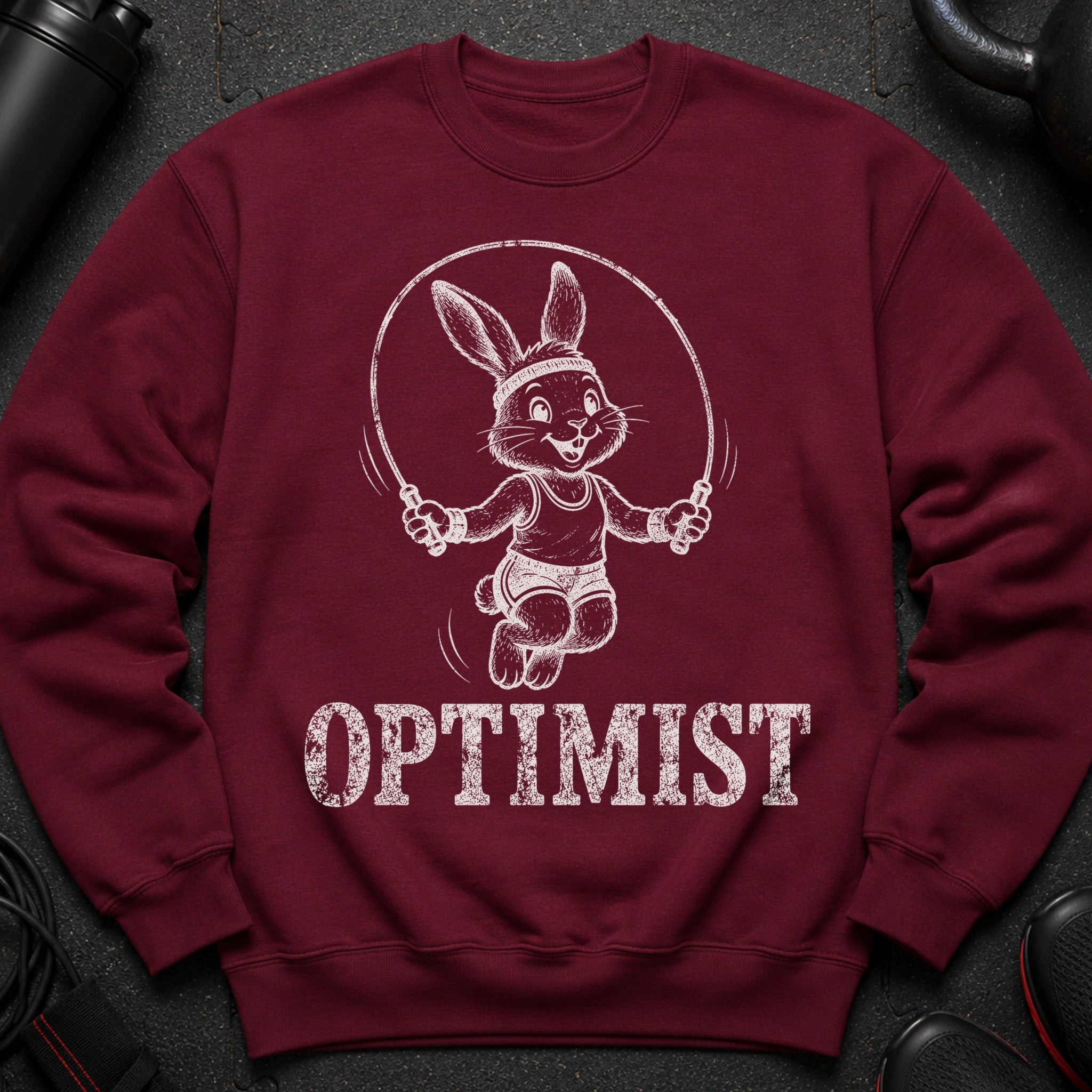 Maroon sweatshirt with a jumping rabbit graphic and the word OPTIMIST.