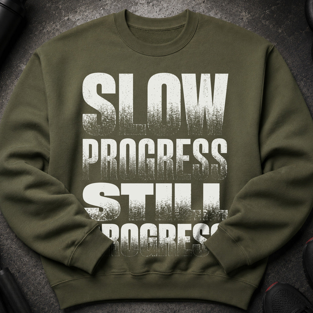 Olive green sweatshirt with distressed white text "SLOW PROGRESS STILL PROGRESS".