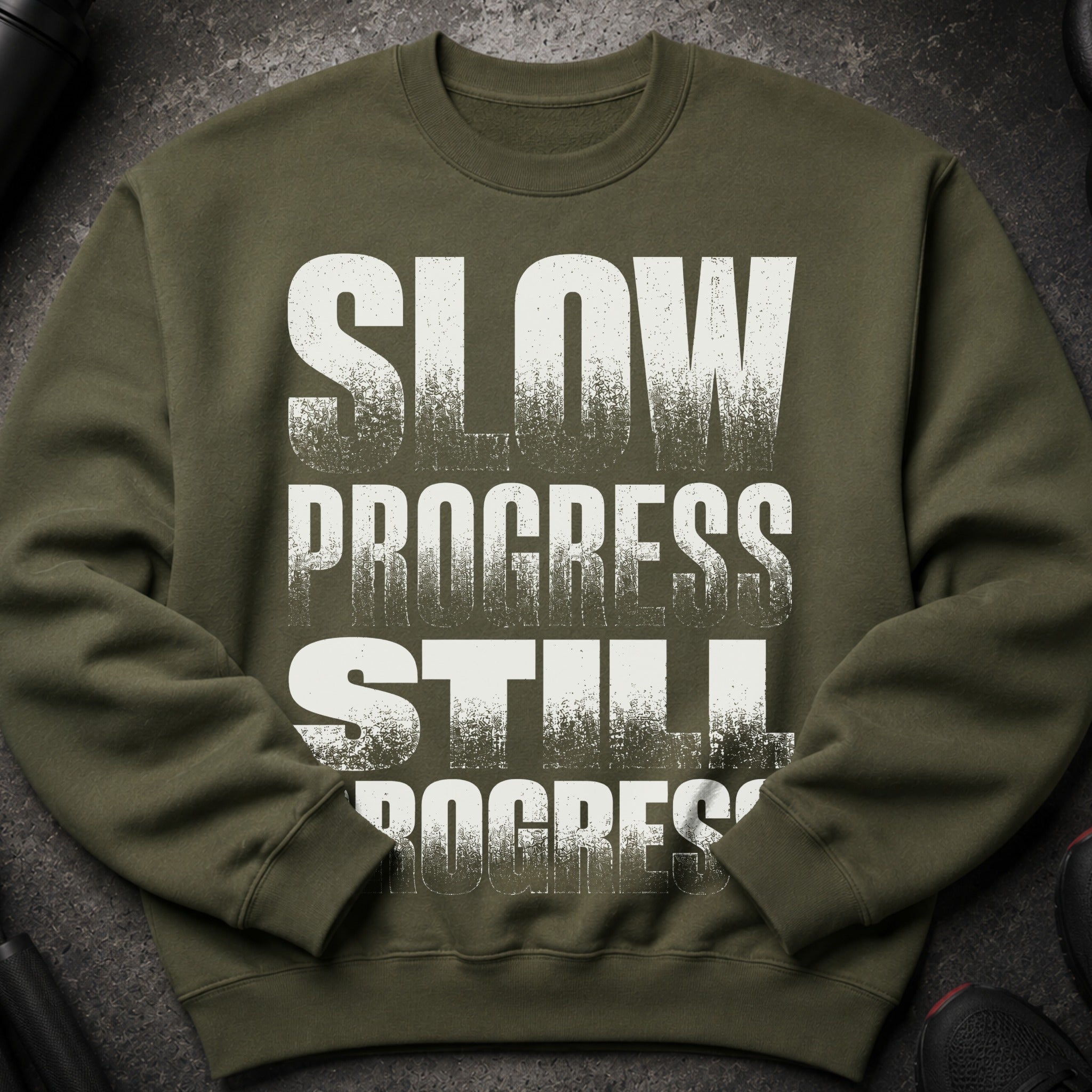 Olive green sweatshirt with distressed white text "SLOW PROGRESS STILL PROGRESS".