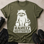 Olive green t-shirt with white graphic of raccoon holding dumbbells and text "RARELY MOTIVATED".