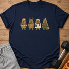 Four capybaras in festive Christmas outfits stand in a line on a navy t-shirt.