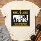 Cream t-shirt with black and yellow "Workout In Progress" graphic about low battery.