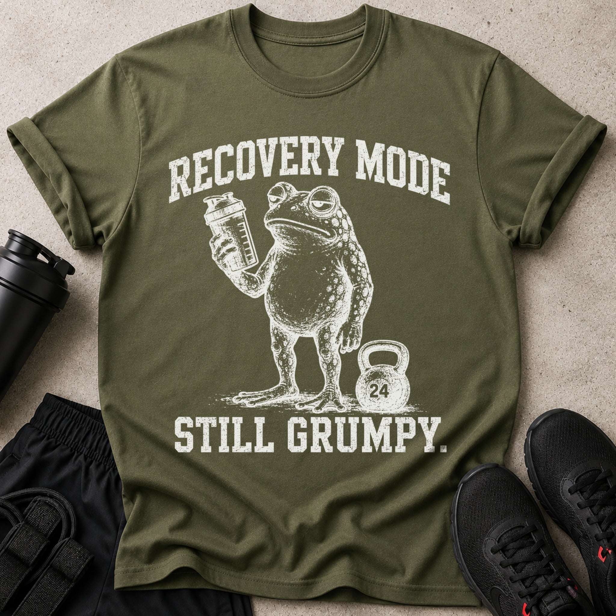 Green t-shirt with grumpy frog holding protein shaker and "Recovery Mode Still Grumpy" text.
