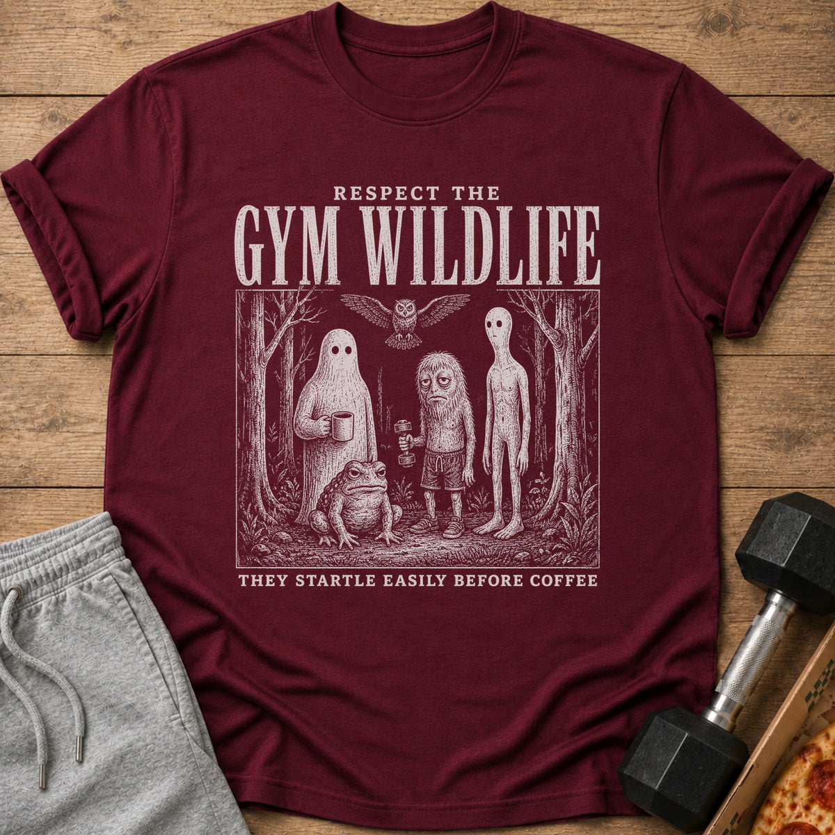 Maroon t-shirt with "Respect the Gym Wildlife" text and illustration of creatures in a forest.