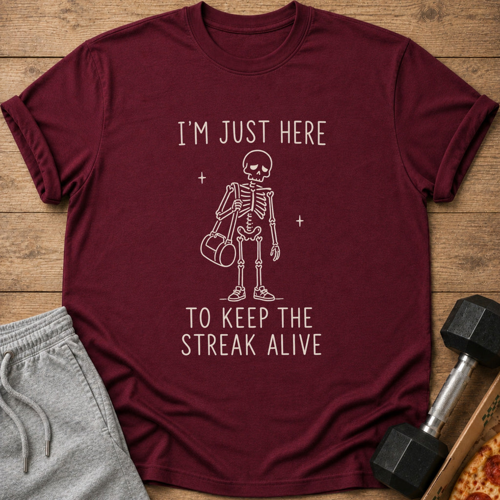 Maroon t-shirt with white text and skeleton graphic saying "I'M JUST HERE TO KEEP THE STREAK ALIVE".